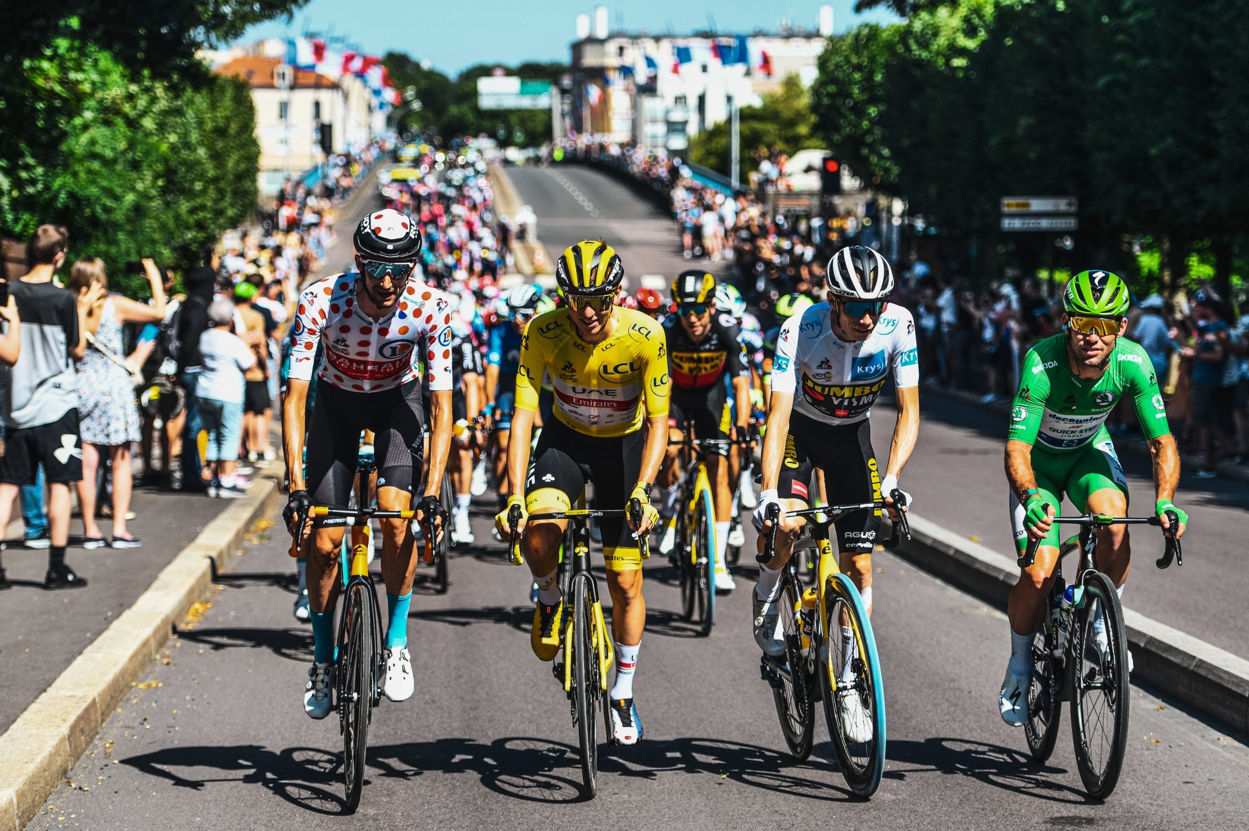 Tadej Pogačar in yellow, polka dot jersey, and green jersey in peloton, TdF 2021