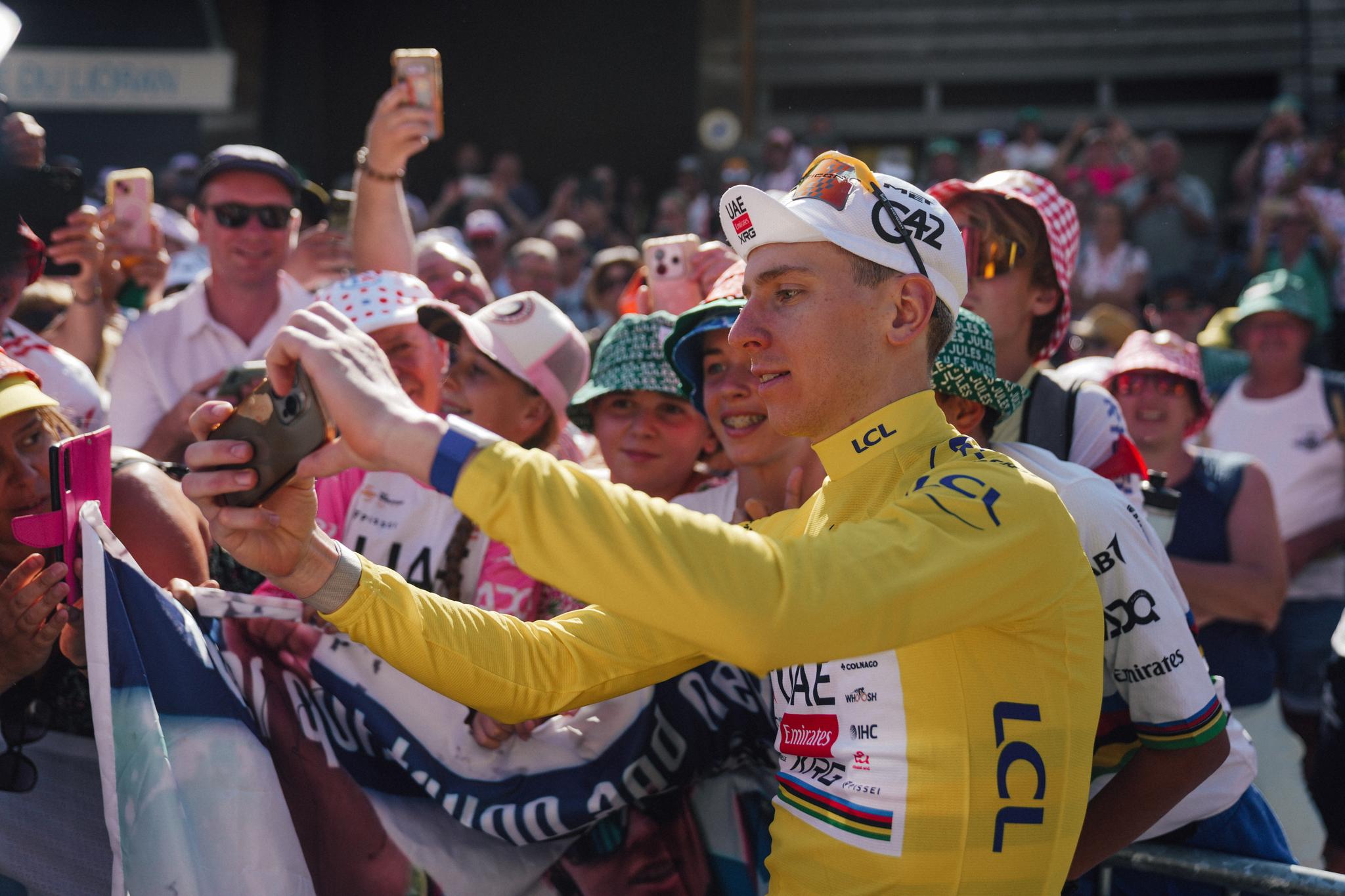 Tadej Pogačar in Yellow Jersey taking a selfie with fans at Tour de France 2026 Stage 10