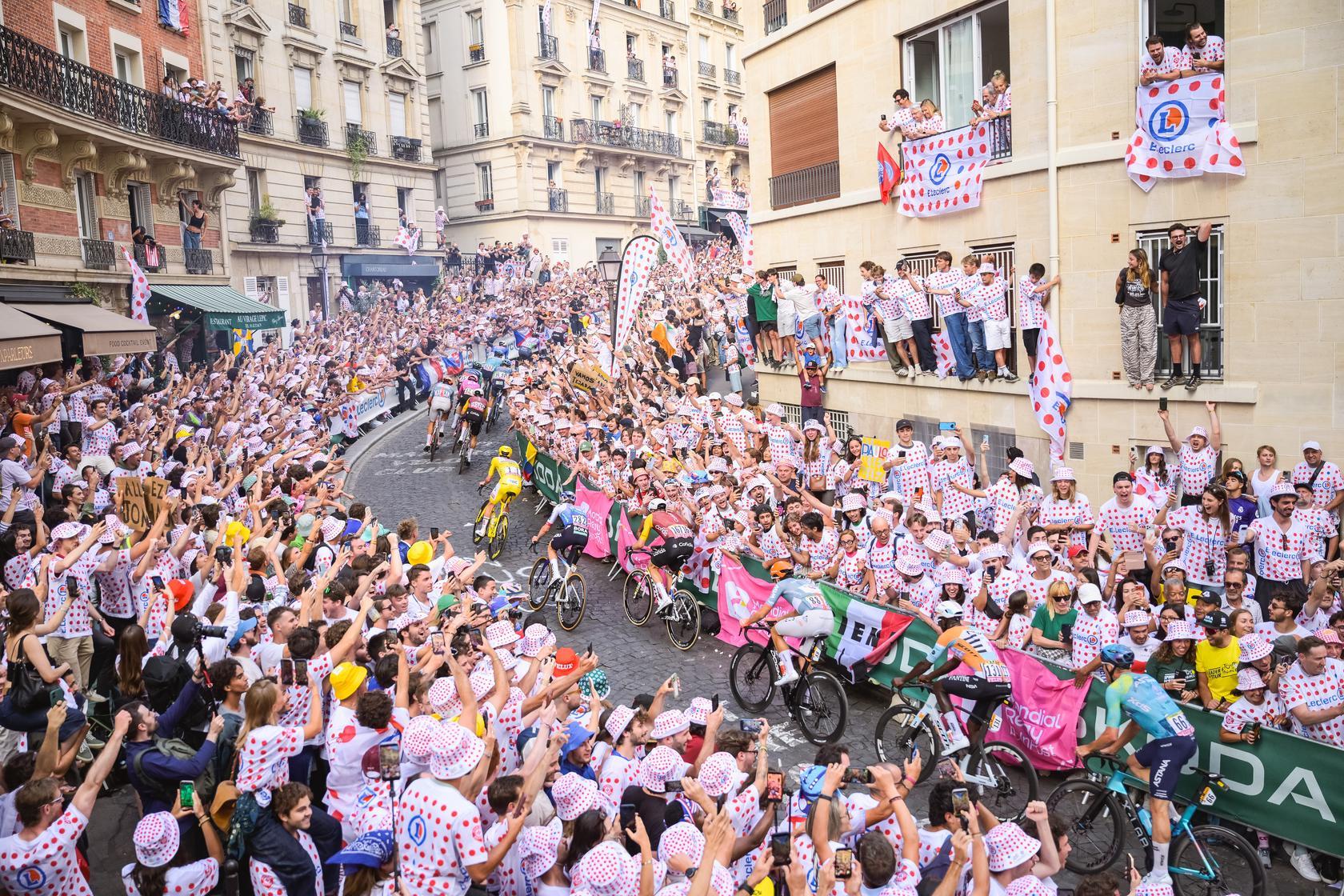 Spectators line Rue Lepic, Paris, cheering on riders, including the yellow jersey leader and polka dot jersey wearer, during the Tour de France stage 21.