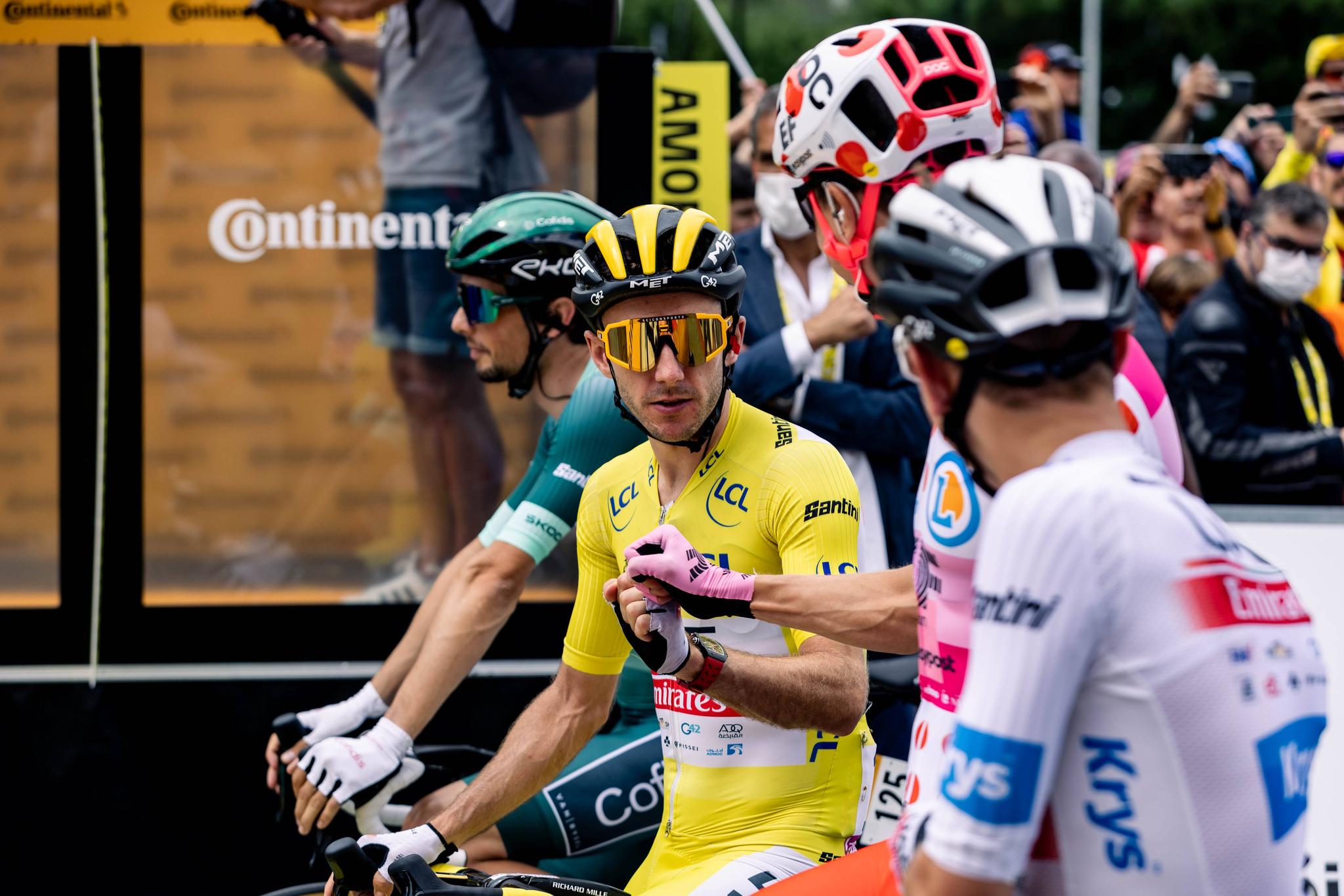 Adam Yates in yellow shakes hands with Neilson Powless alongside Victor Lafay and Tadej Pogačar at Tour de France 2023 Stage