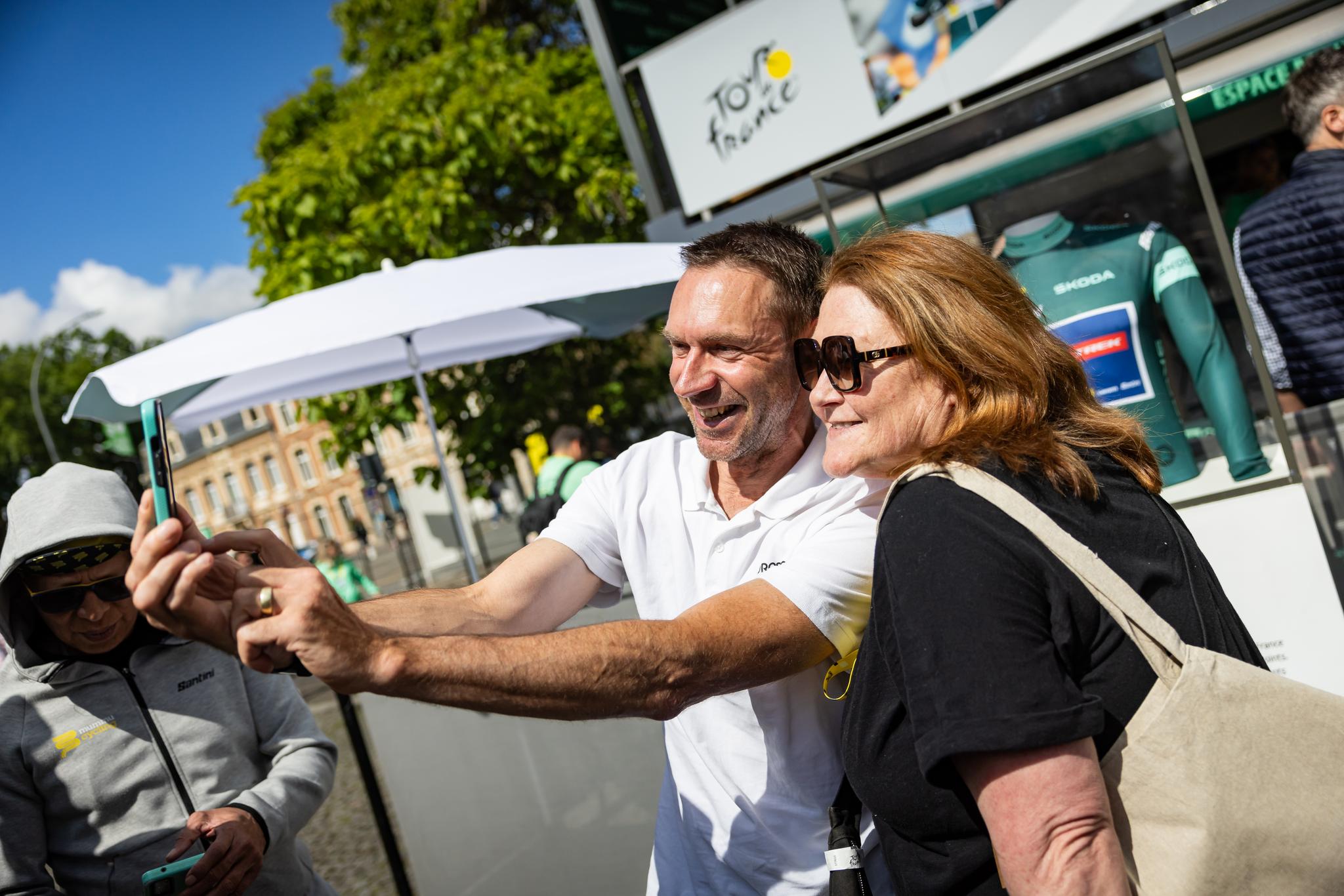 Tour de France scene with fans taking a selfie.