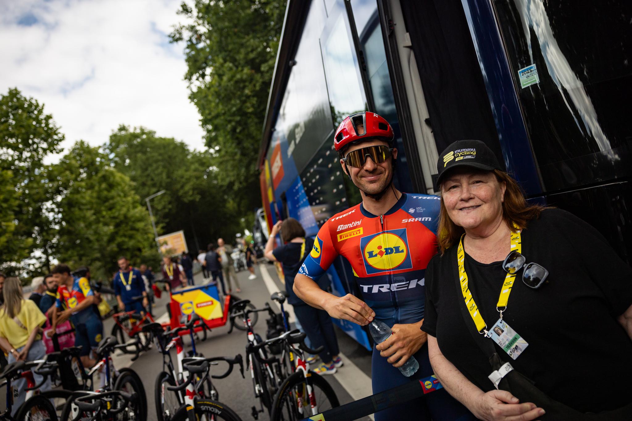 Lidl-Trek rider with Mummu Cycling guest near team bus.