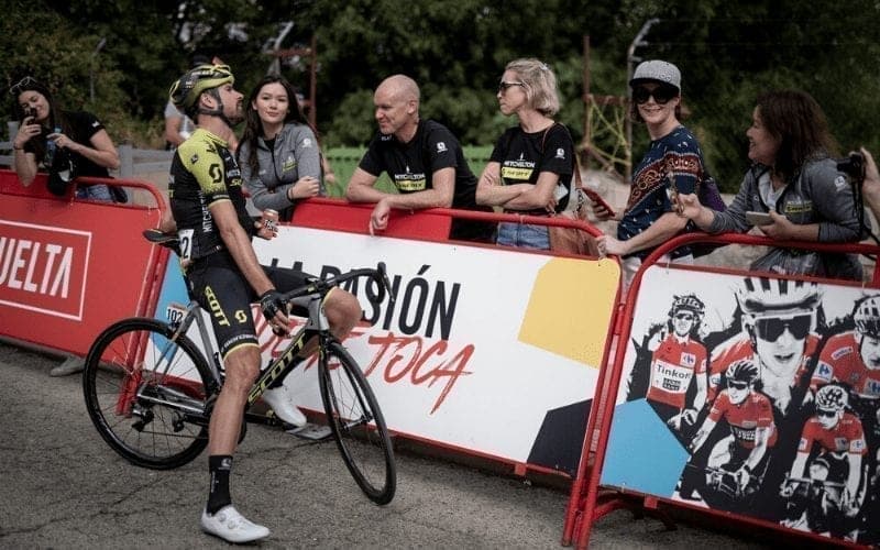 Cyclist in black/yellow kit with fans at Vuelta a España