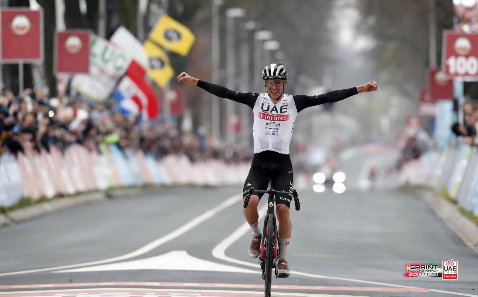 Tadej Pogačar (UAE) celebrates victory, arms raised.