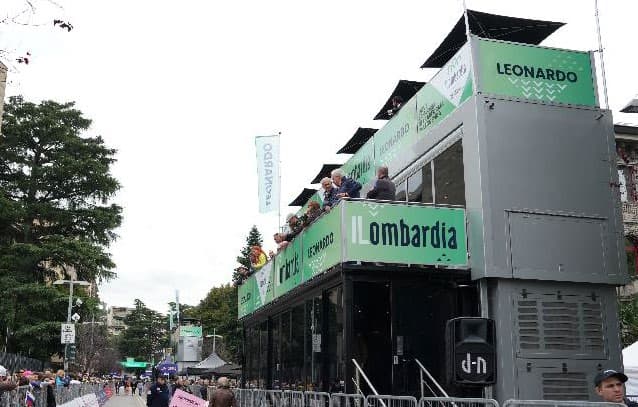 The Il Lombardia hospitality truck at the finish line, guests on the upper deck above the straight